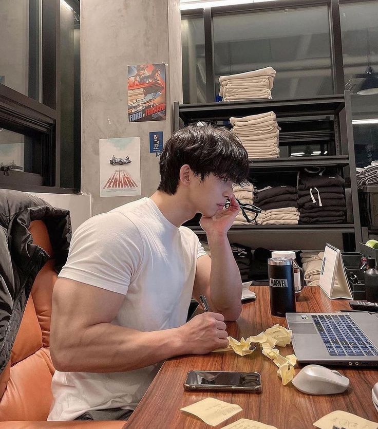 a man sitting at a desk with a laptop computer