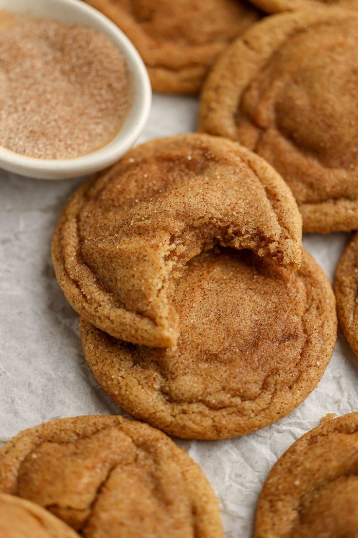 some cookies are sitting next to a bowl of sugar