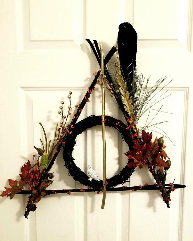 a wreath made out of branches and feathers hanging on a door