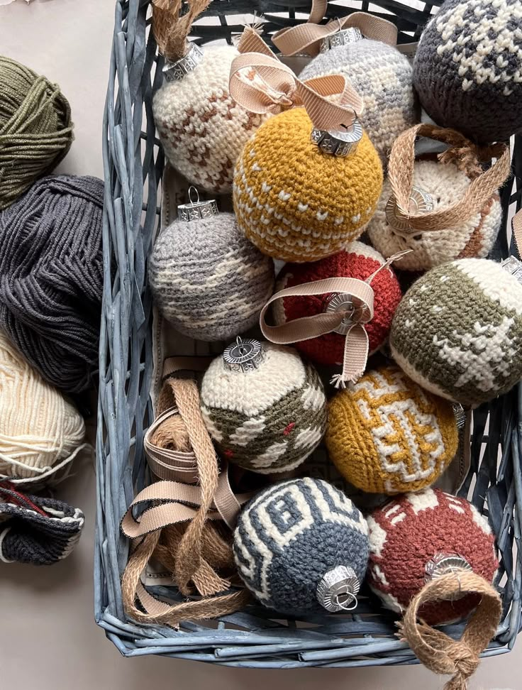 a basket filled with balls of yarn and crochet on top of a table