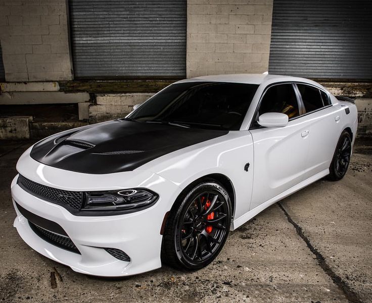 a white and black car parked in front of two garage doors