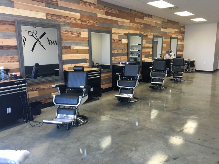 an empty barber shop with chairs and mirrors