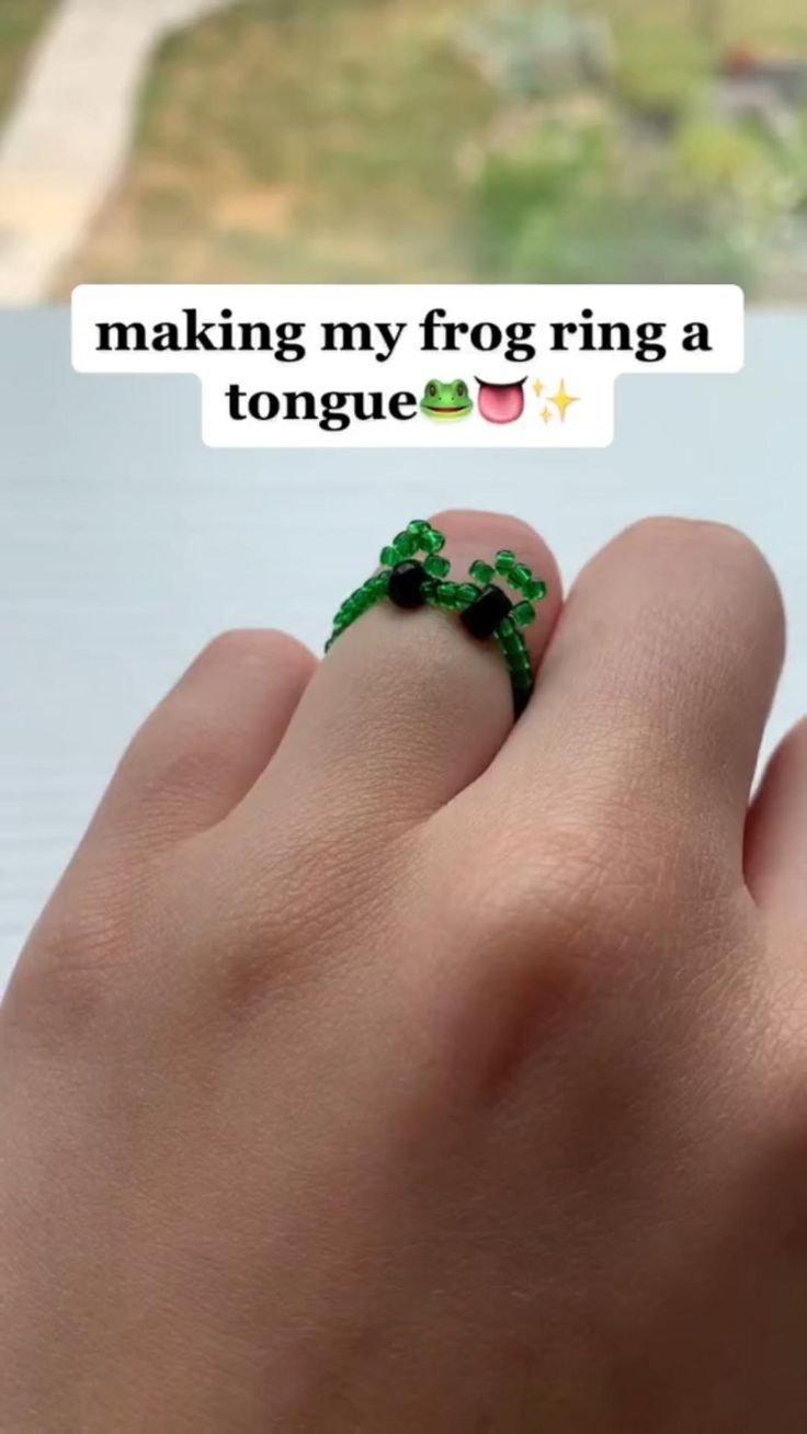 someone is holding their finger with a ring on it that says making my frog ring a tongue