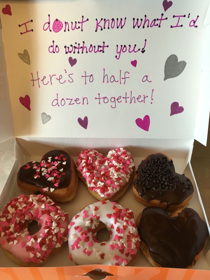 a box filled with lots of donuts covered in frosting and sprinkles