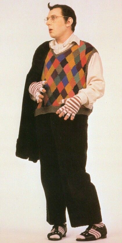 a man in black pants and a colorful sweater