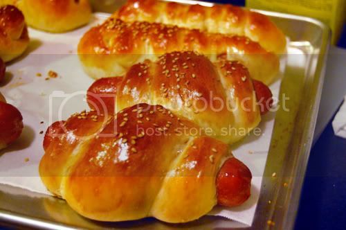 hot dogs wrapped in bread on a tray