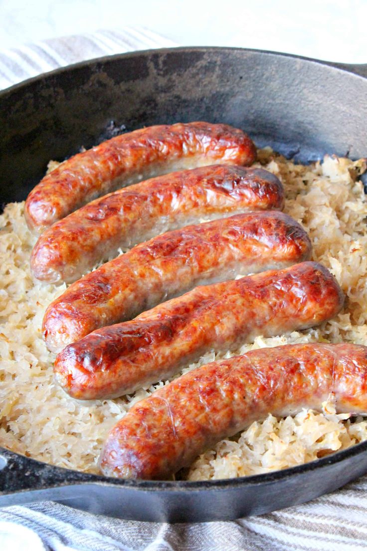 sausages and rice in a skillet ready to be cooked on the stove top