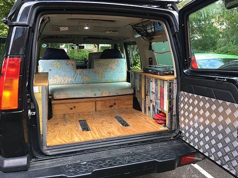 the back end of a vehicle with its trunk open and books in it's cargo compartment