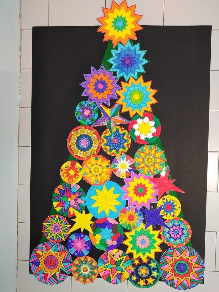 a colorful christmas tree made out of paper on a black background with white tile wall