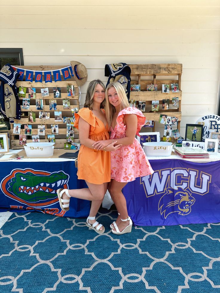 two women standing next to each other in front of a table with decorations on it