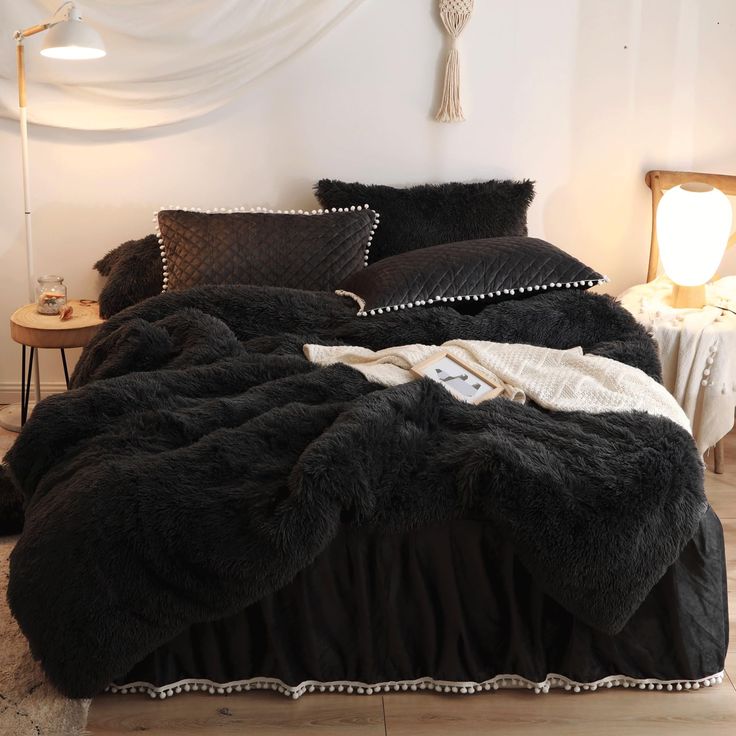 a bed with black comforter and pillows on it