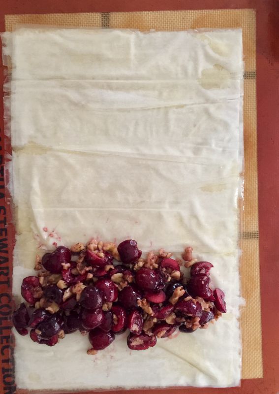 grapes and walnuts are sitting on top of parchment paper, ready to be baked