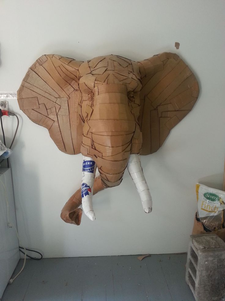 an elephant made out of wood is hanging on the wall