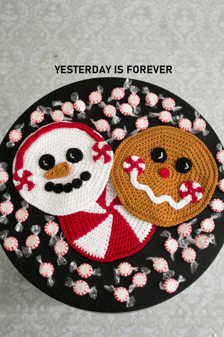 two crocheted coasters on top of a black and white plate with flowers