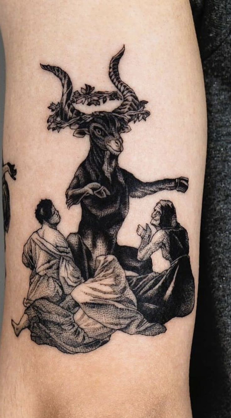 a black and white photo of a woman's arm with an image of a demon on it