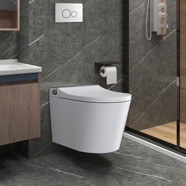 a modern bathroom with grey marble walls and flooring, including a white toilet in the corner