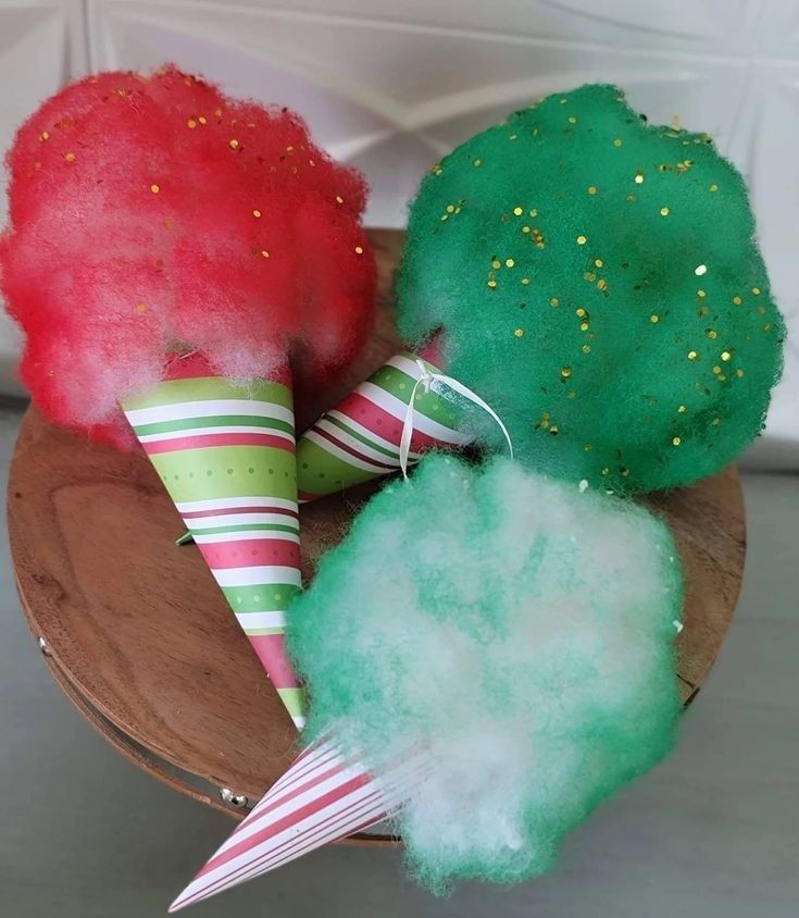 three different colored cotton cones sitting on top of a wooden bowl