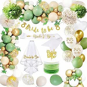 a green and gold bridal party set up with balloons, streamers, cake toppers