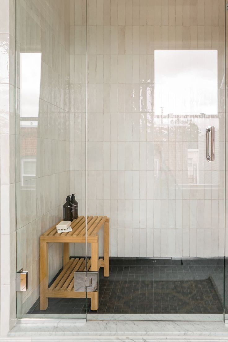 a bathroom with a stand up shower next to a window