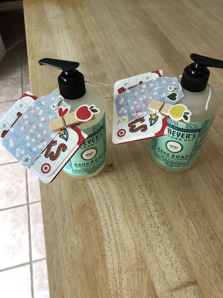 two hand sanitizers sitting on top of a wooden table