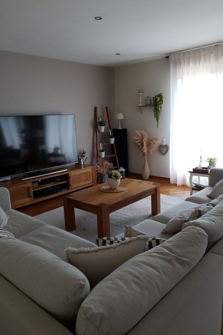 a living room filled with furniture and a flat screen tv on top of a wooden table