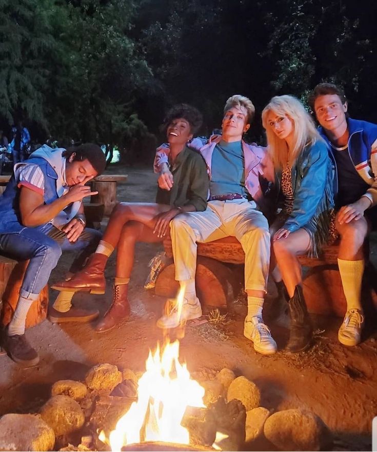 a group of people sitting around a campfire