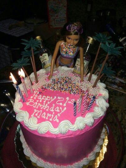 a birthday cake with candles and a doll on top