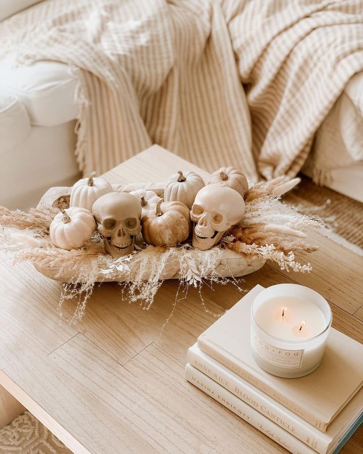 a wooden table topped with candles and skulls on top of each other next to a book