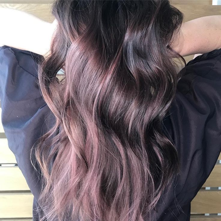 the back of a woman's head with long, dark hair and purple highlights