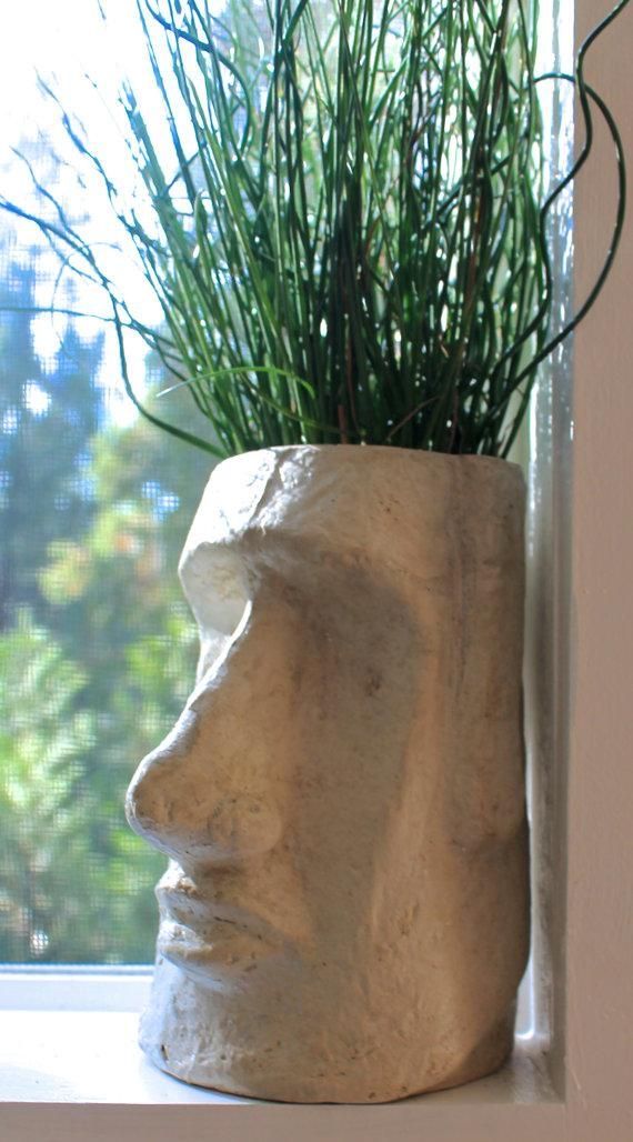 a plant in a clay head on a window sill