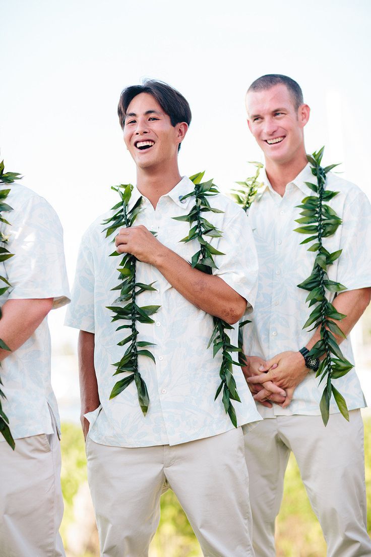 three men in white shirts with green leaves around their necks, smiling at the camera