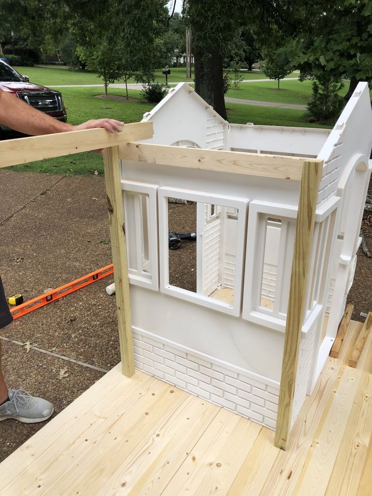 a man is building a doll house out of plywood