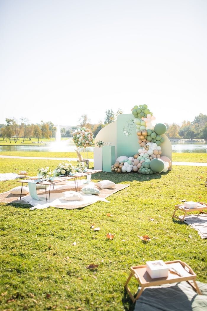 an outdoor wedding setup with balloons and flowers