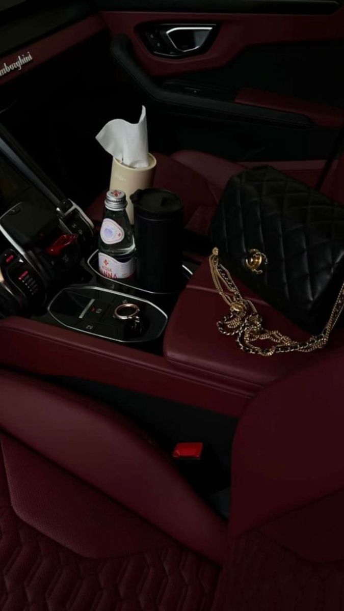 the interior of a car with various items in it and a handbag on the floor