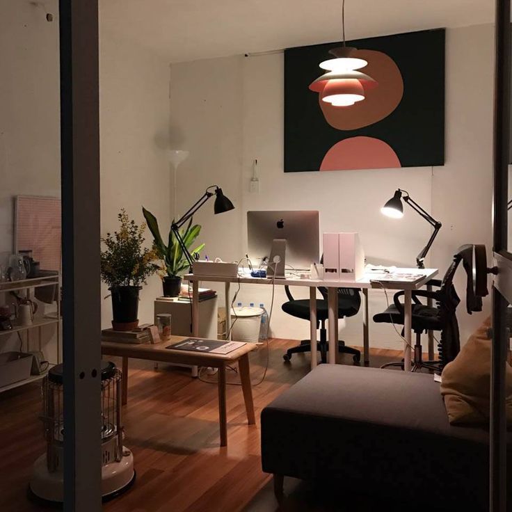 a living room filled with furniture and a painting on the wall above it's desk