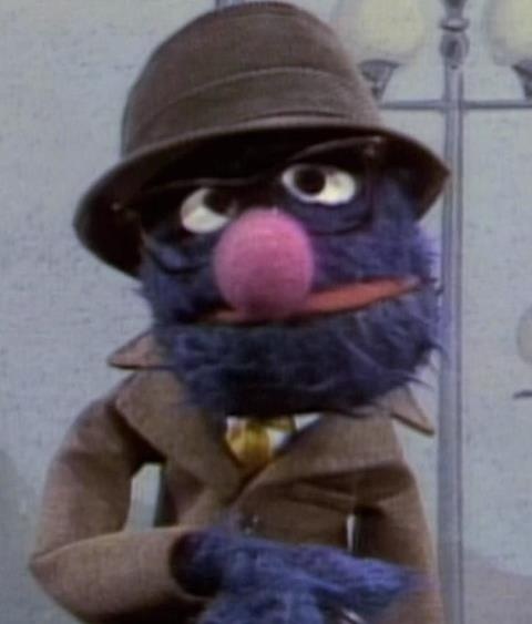 the muppet is dressed in a suit and hat