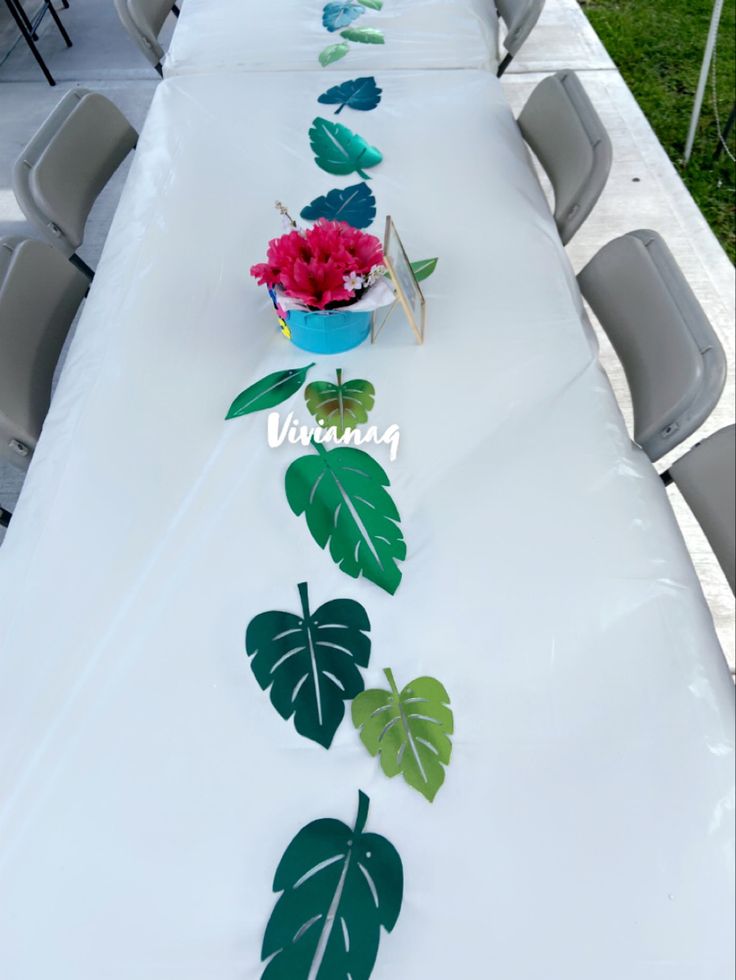 a long table with some flowers and leaves on it