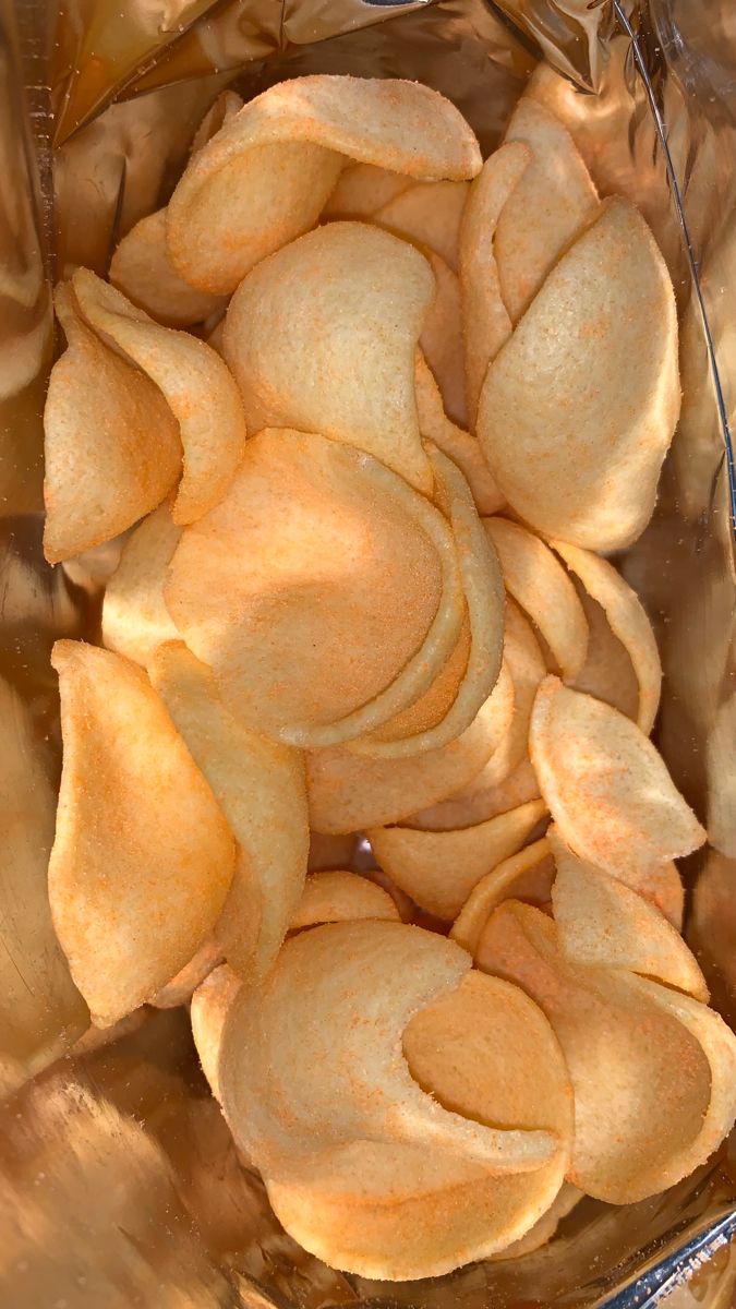 a glass bowl filled with potato chips on top of a table