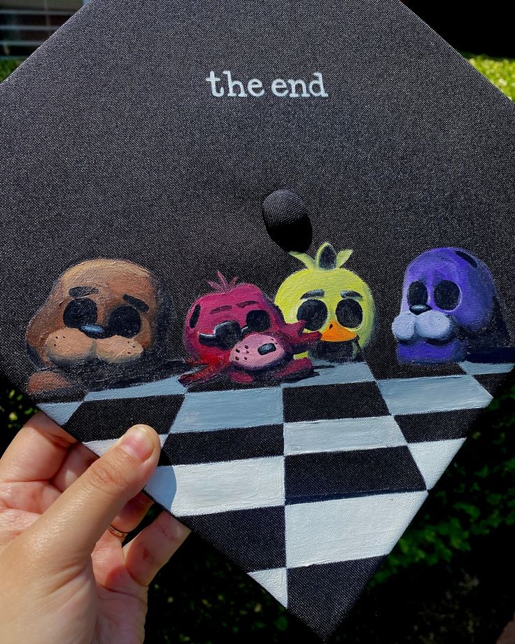 someone is holding up a graduation cap with the characters on it