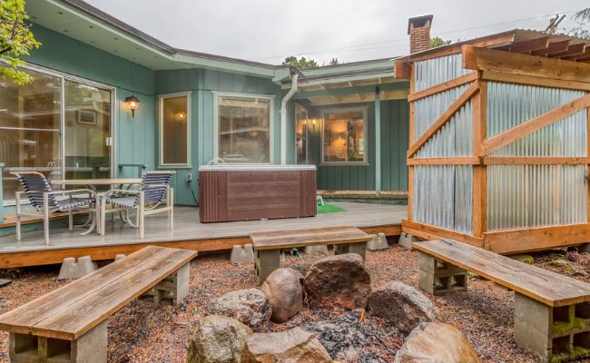 a house with a patio and wooden benches