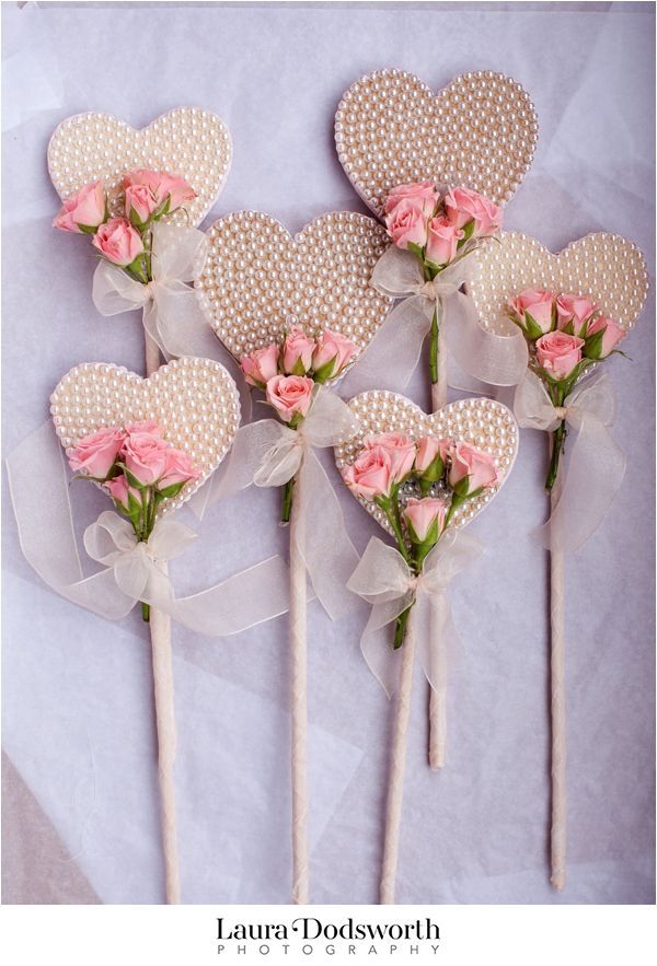 four heart shaped lollipops with pink roses on them