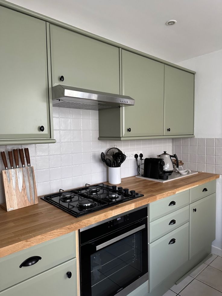 a stove top oven sitting inside of a kitchen next to wooden counter tops and cabinets