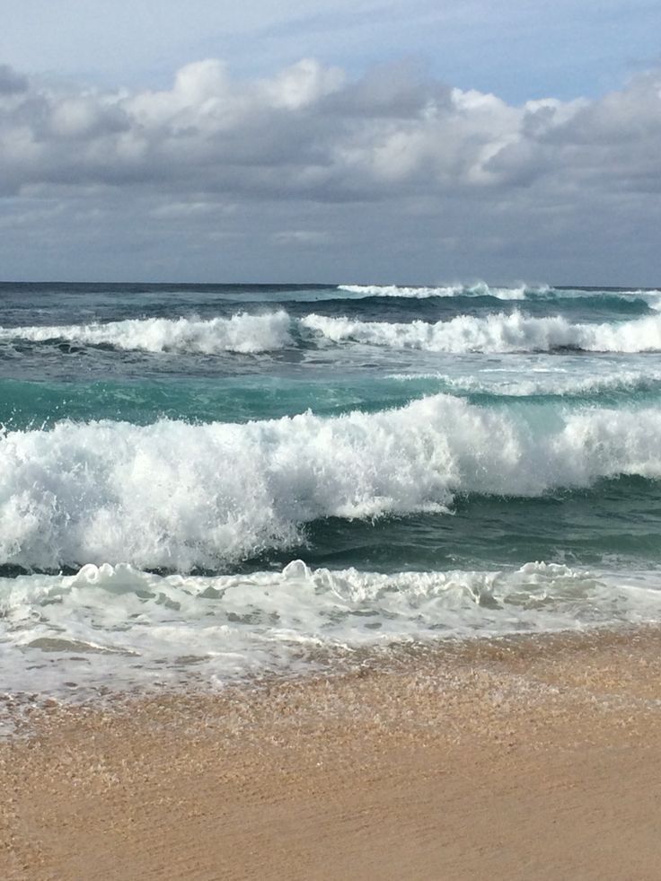 the ocean waves are crashing on the beach