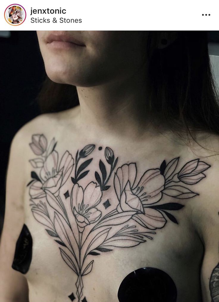 a woman's chest with flowers and leaves tattooed on the top half of her body