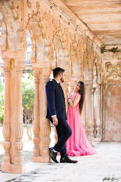 a man and woman standing next to each other in front of an archway with text on it