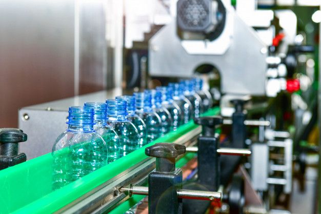 bottles are lined up on a conveyor belt