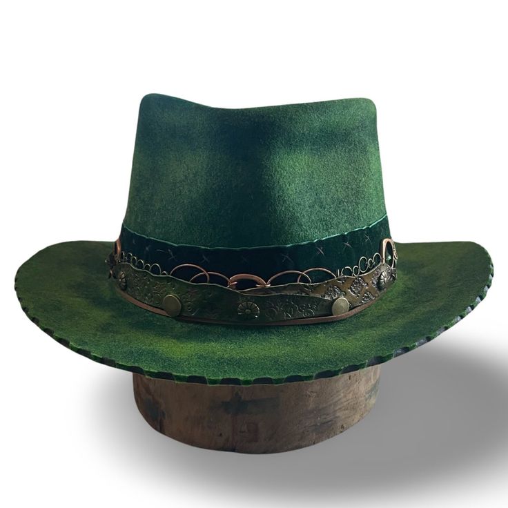 Distressed green felt hat ... 💯 Australian Wool hat distressed , burned , and hand dyed ... If you like green this hat is for you! The color looks deep forest indoors but brightens up under the sun with whispers of yellow undertones  I handcrafted the leather hatband ( that is sewn in ) and tied it together with a beautiful silk tie ( comes with extra fabric ties) ... I sewed in bronze and copper chain details to adda bit of toughness to the romance if the hat .. This is a head turning hat and as always ALL of my hats are one of a kind so make it your own  Size 23.5 inches  Brim 2.5 inches  Crown 4 inches  Sewn in soft leather sweatband  Satin liner  Shipping included Cheap Green Brimmed Hat, Western Green Hat For Country Events, Western Green Hat Band For Festivals, Western Green Hat Bands For Festival, Green Western Style Hat Band For Festivals, Bohemian Green Hat Bands For Country Events, Bohemian Green Hat Band For Country Events, Green Western Hat Bands For Kentucky Derby, Western Green Hat Bands For Kentucky Derby