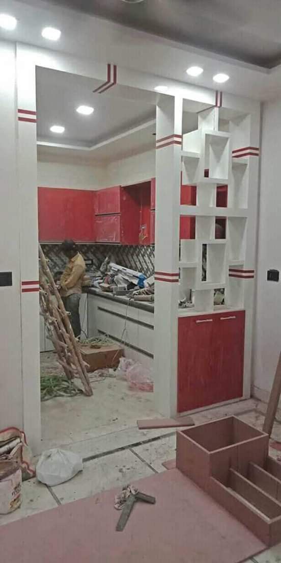 an unfinished kitchen with red and white cabinets