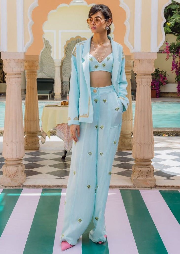 Bralette - handwoven silk, embroidered with little sparkly palm tree motifs. Pants - high - waisted handwoven silk trousers embroidered with little sparkly palm tree motifs. Jacket - oversized, handwoven silk, hand embroidered with beaten gold vintage Indian motifs. Luxury Blue Art Silk Palazzo Set, Luxury Festive Blue Palazzo Set, Luxury Chanderi Bottoms For Festive Occasions, Traditional Luxury Pant Set For Festivals, Luxury Traditional Multicolor Bottoms, Luxury Palazzo Set With Zari Weaving, Luxury Bollywood Pant Set For Festivals, Luxury Blue Embroidered Palazzo Set, Luxury Traditional Pants For Spring