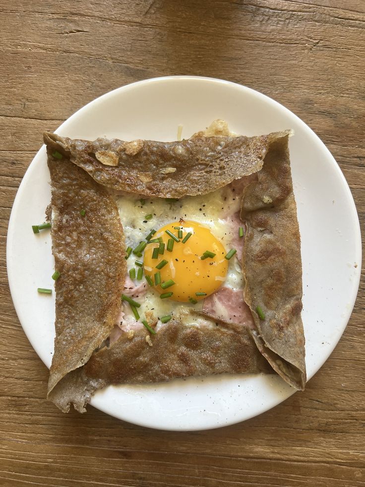 an egg is in the middle of some pita bread on top of a white plate